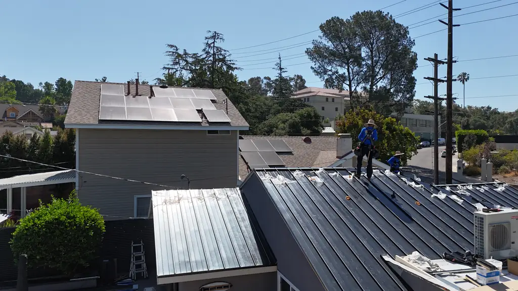 Eclipse Metal Roofing crew on a black standing seam roof in a Los Angeles neighborhood